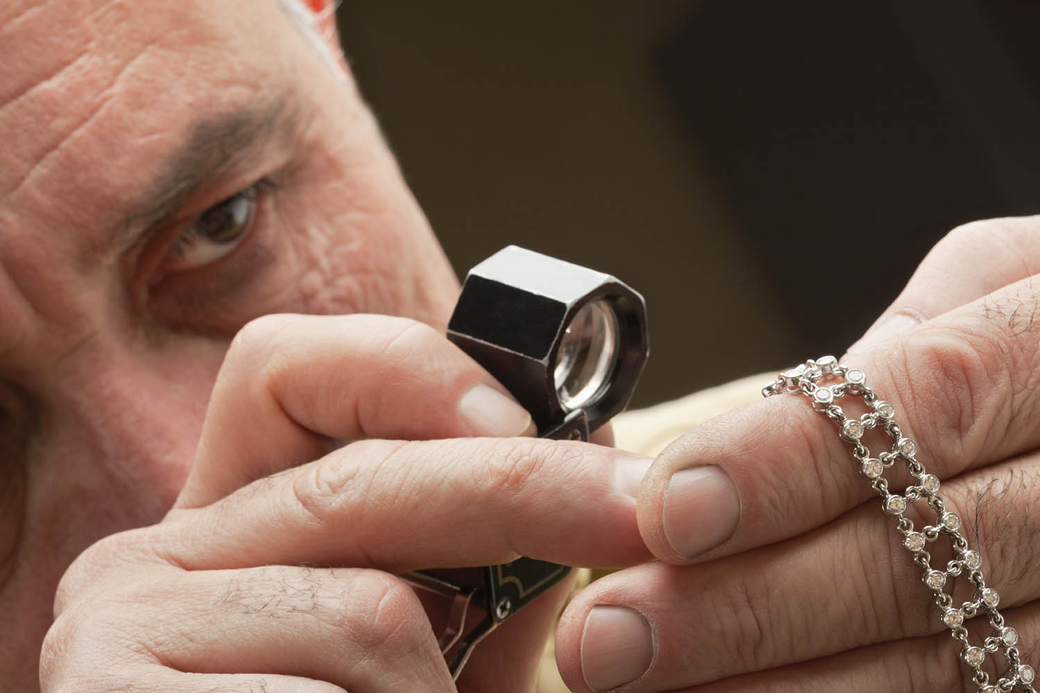 jeweler looking in loupe at a bracelet