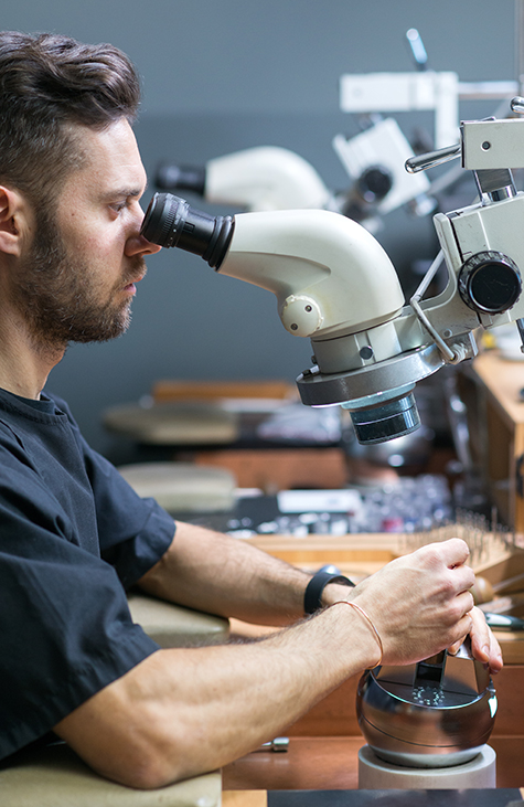 Jeweler viewing gemstones with microscope